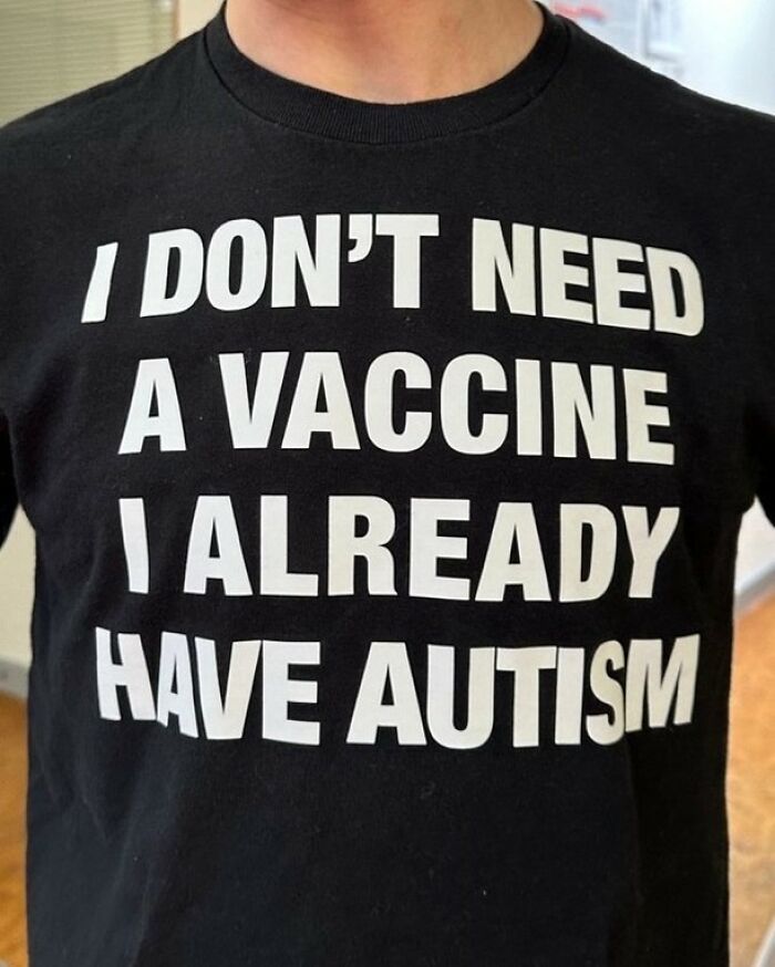 A person wears an iconic shirt that boldly states I Don't Need A Vaccine I Already Have Autism.