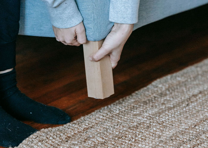 Hands adjust a bed frame, symbolizing the domestic challenges and worst first dates.