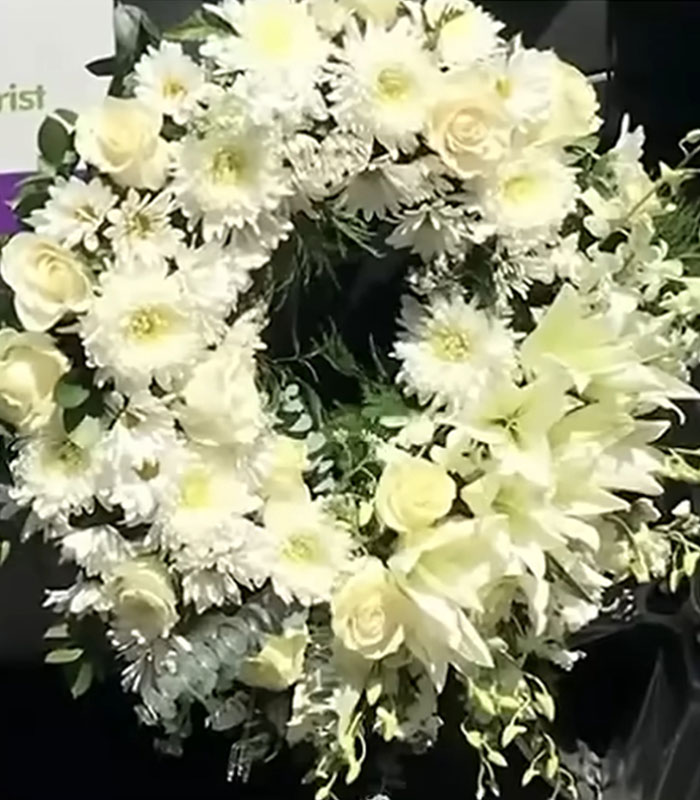 A beautiful white floral wreath, representing the karma related to the eBay campaign against an old couple.