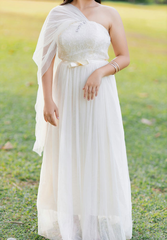 A woman in a flowing white dress at an outdoor wedding event, representing common happenings at weddings.