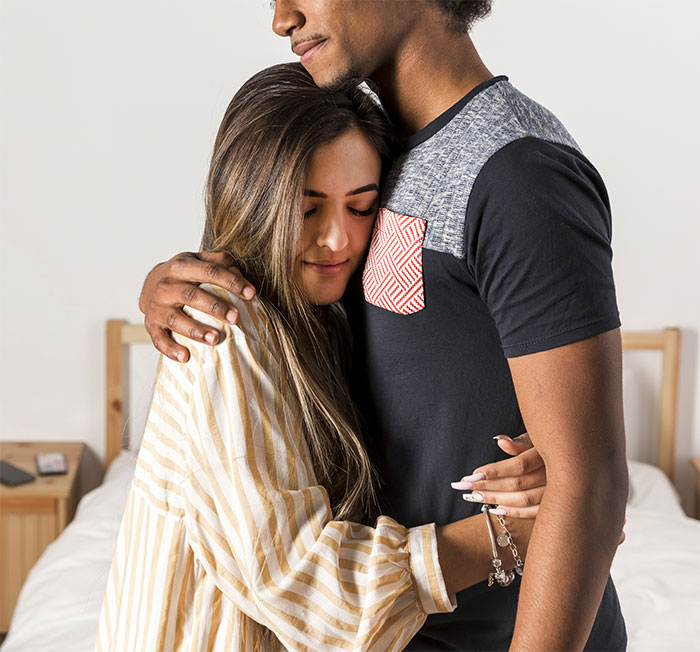 Image of a couple hugging, highlighting the emotional aspect of moving into a guy's house and boundaries.