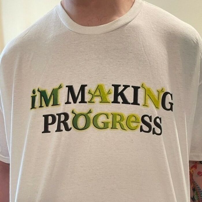 A person wears an iconic shirt with the text I'm Making Progress in yellow and green letters.