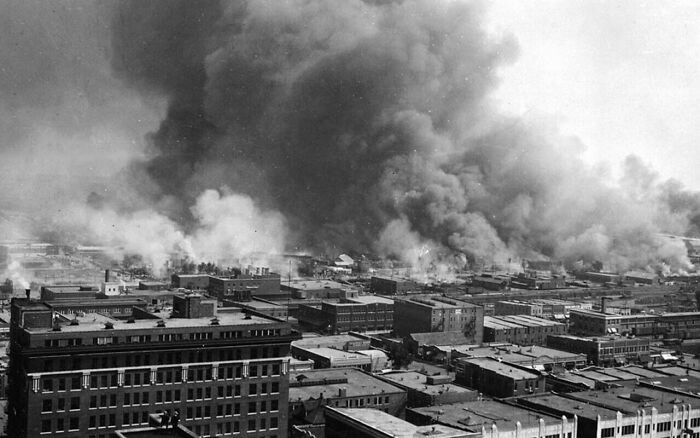 An aerial view of a city engulfed in smoke and fire, a devastating and fascinating photo from American history.