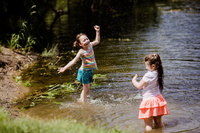 Two young girls happily splashing in water, representing the vibrant line between life and what comes after.
