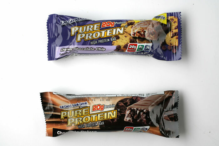 Two Pure Protein high protein bars, chocolate chip and chocolate deluxe, representing healthy habits and dietary choices.