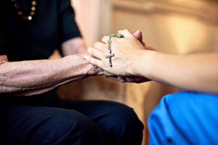Two people holding hands, one with a rosary, representing support when people walked out without their therapist.