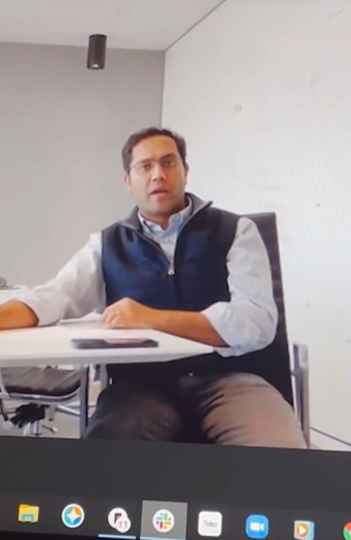 A CEO on a video call, appearing to discuss being tricked into losing his job after firing 900 workers.