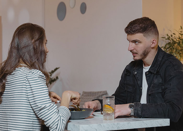 Man and woman eating at a restaurant, an example of a first date with women.