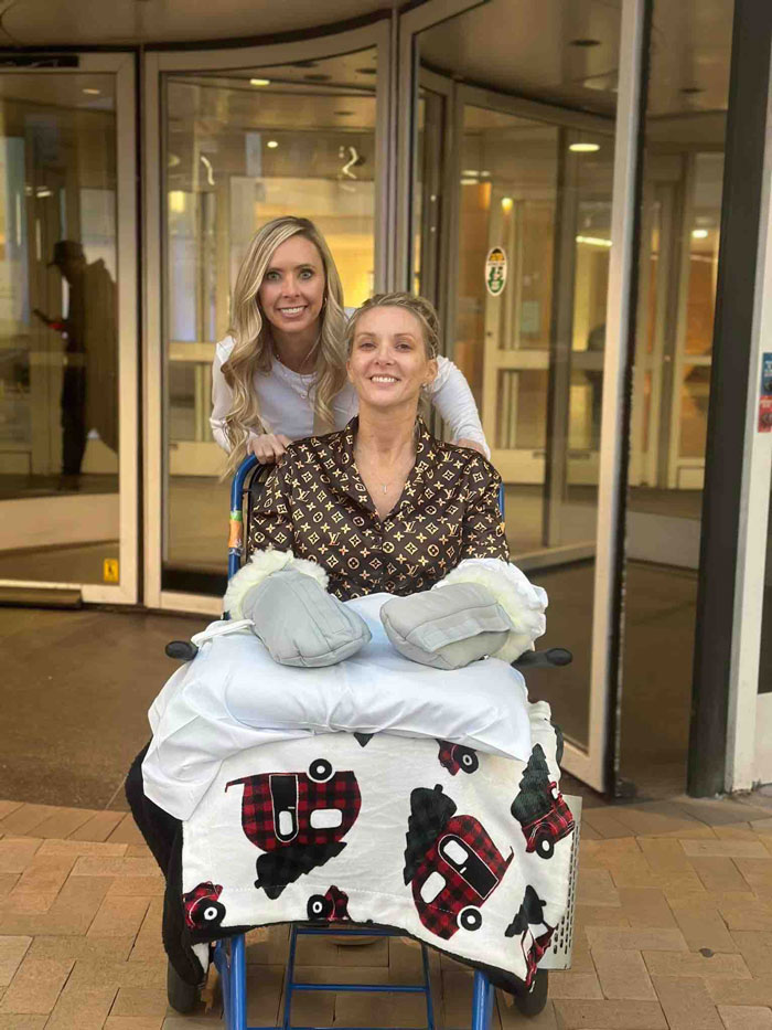A woman who had both legs and hands amputated after surgery is wheeled out of a building. A woman who had both legs and hands amputated after surgery is wheeled out of a building.