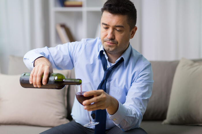 A man pours wine, representing a potential reason for walking out without his therapist.