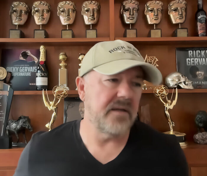 Ricky Gervais in a cap, surrounded by awards, revealing his reason to marry partner of 44 years. Ricky Gervais in a cap, surrounded by awards, revealing his reason to marry partner of 44 years.
