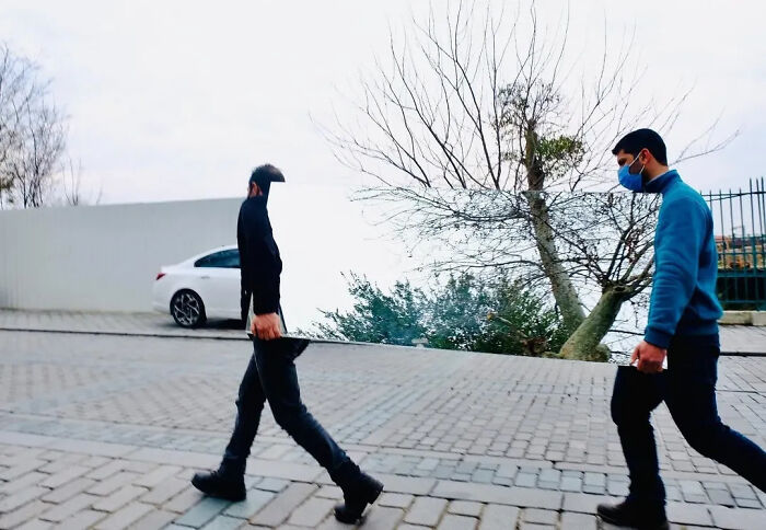 Candid moments from the streets, two men carrying a large mirror, with one appearing to blend into the background due to the reflection.