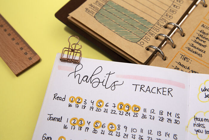 A close-up of a habits tracker notebook with various daily activities marked, illustrating the tracking of personal habits.