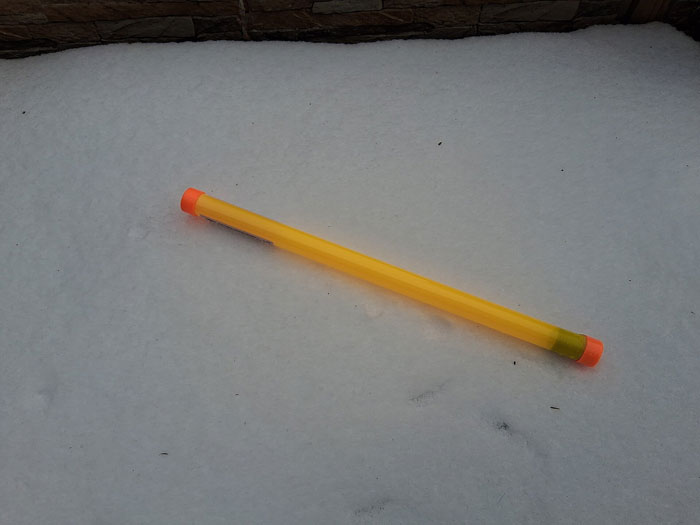 A yellow object resembling a pencil or marker with orange caps on a field of white snow, showing how people forgot the name of something.