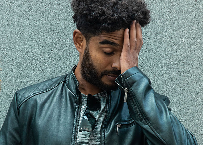 Man with hand on face looking distressed during a worst first date.