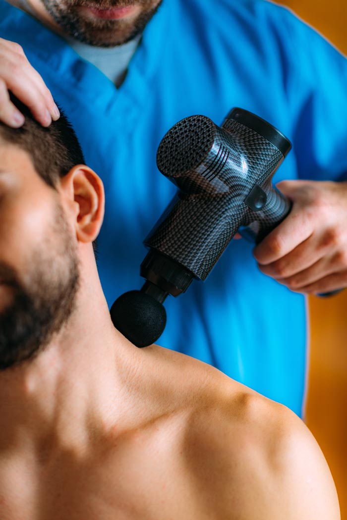 Man receiving a shoulder massage, highlighting dumb work rules about physical therapy at the office.