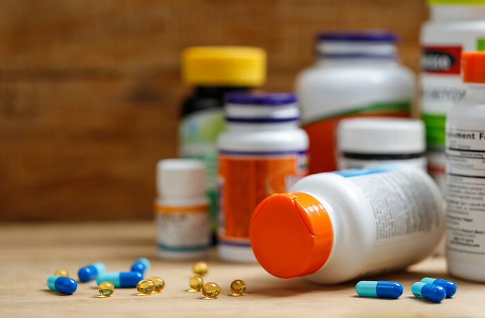 Various bottles of pills and supplements on a wooden surface, highlighting possibly over-glorified healthy habits.