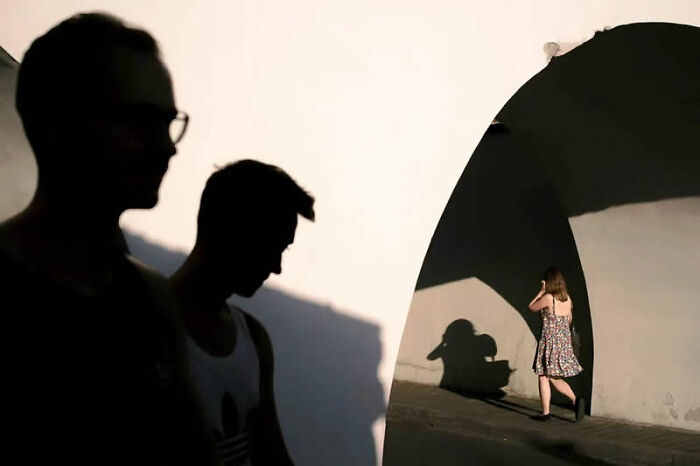 Best street photos from the Macadam Awards capture silhouettes of people and shadows on a white wall.