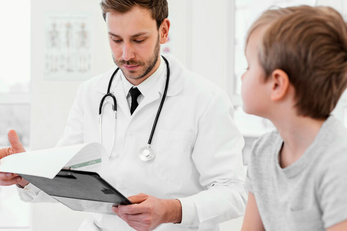 A doctor reviews a chart with a young patient. Doctors reveal the diagnoses that were the hardest to deliver.