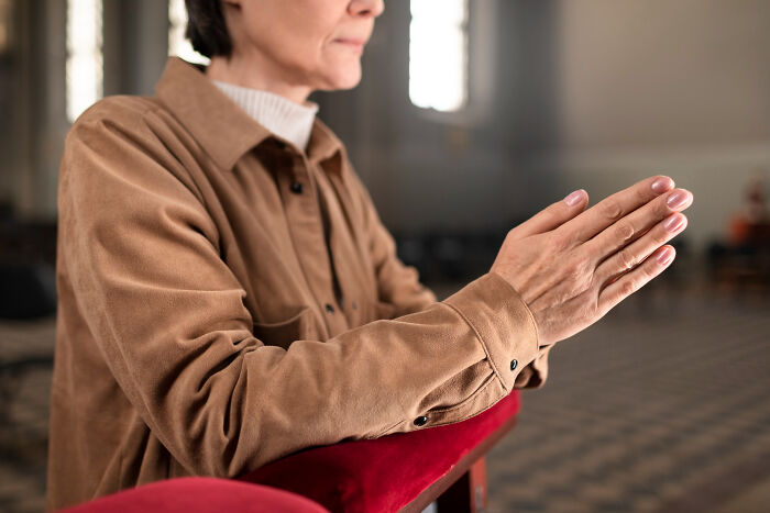 A person with clasped hands, deep in thought, perhaps reflecting on their therapy journey and reasons for leaving.