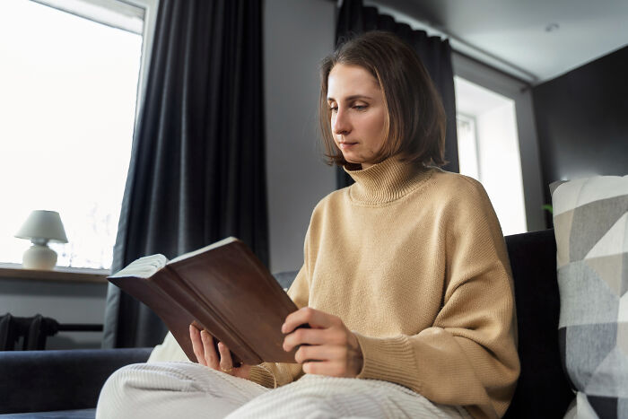A woman reading a book at home, reflecting on why people walked out without their therapist.