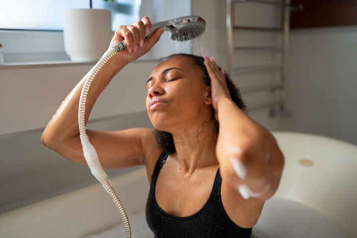 Woman showering with closed eyes, a moment of introspection between life and what comes after.
