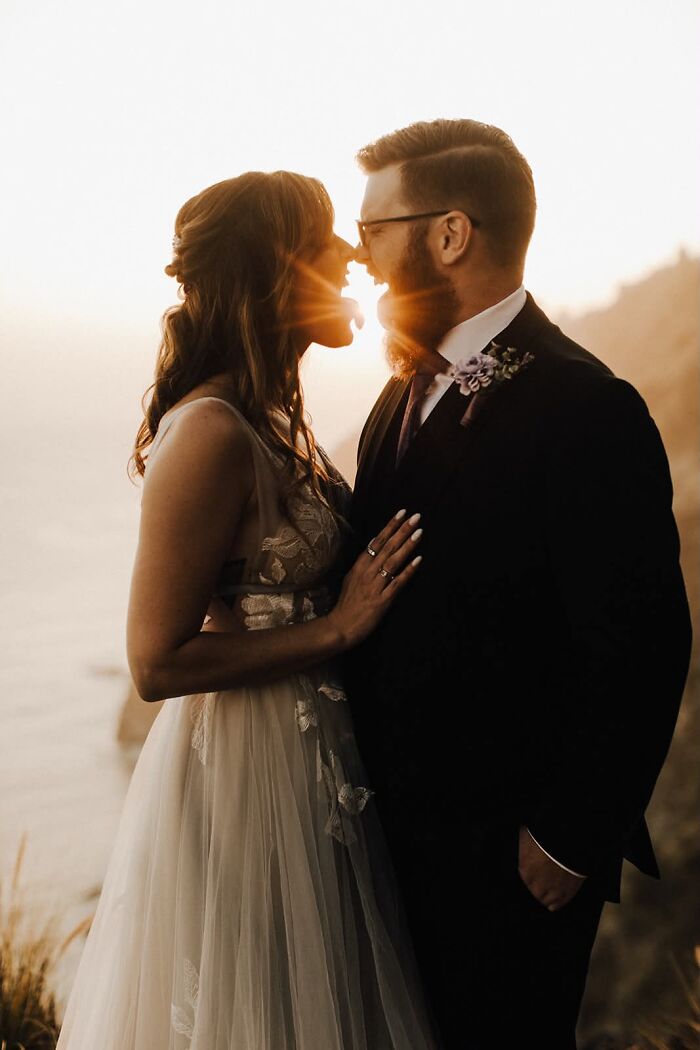 Romantic, funny wedding photo of a bride and groom kissing at sunset, creating an iconic moment.