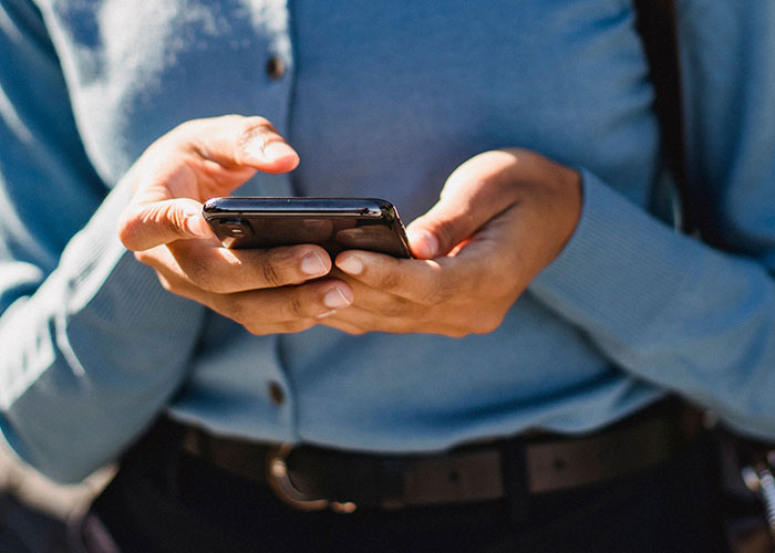 Hands holding a smartphone, possibly texting or looking up information about first dates.
