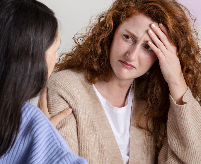 A worried bride with red hair holds her head, contemplating problems with her wedding and fiancée. A worried bride with red hair holds her head, contemplating problems with her wedding and fiancée.