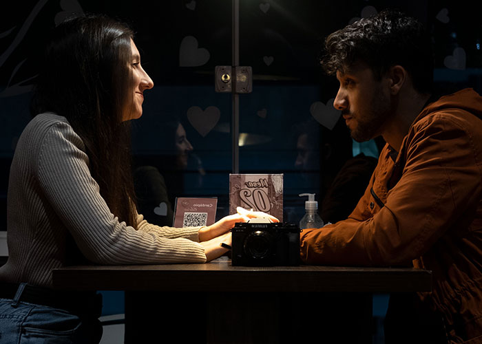A man and a woman on a first date at a restaurant, sharing a moment.