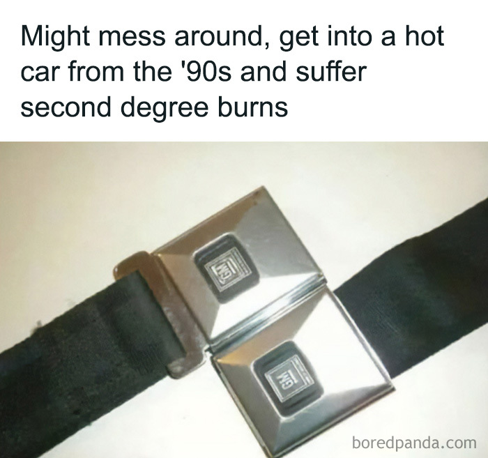 A close-up of a vintage GM seatbelt buckle, a classic car feature from the 90s.