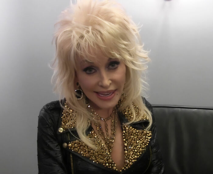 Dolly Parton poses, showcasing her real hair, with her iconic wigs off, stunning fans with her natural beauty. Dolly Parton poses, showcasing her real hair, with her iconic wigs off, stunning fans with her natural beauty.
