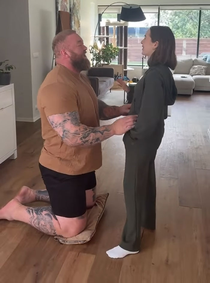 Game of Thrones The Mountain on one knee, speaking with his wife indoors. Game of Thrones The Mountain on one knee, speaking with his wife indoors.
