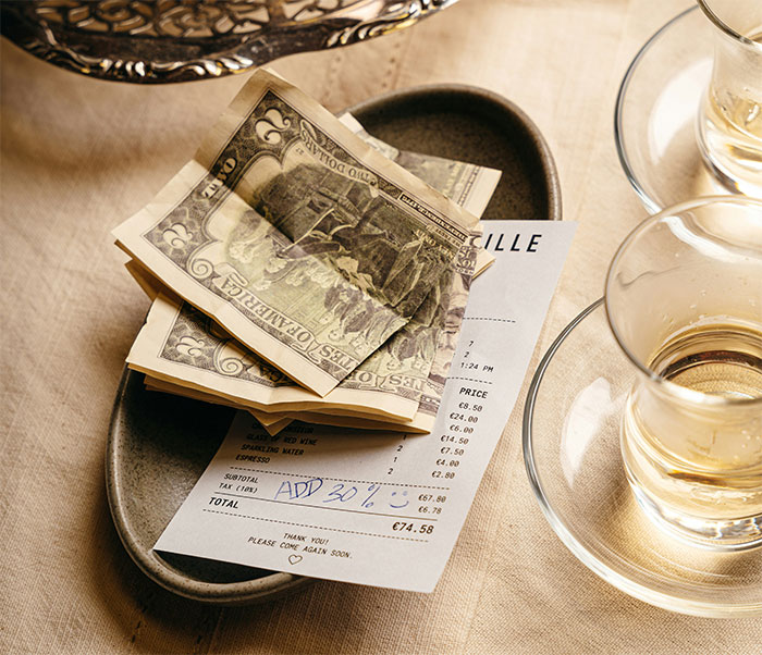 A restaurant bill with money and a 30% tip, symbolizing people who found someone to pay their bills. A restaurant bill with money and a 30% tip, symbolizing people who found someone to pay their bills.