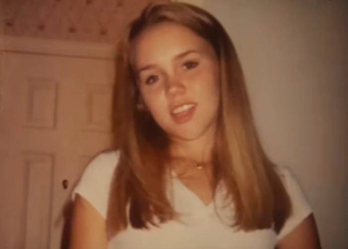 A young woman looks at the camera. She escaped a serial criminal and shares the warning sign she ignored.