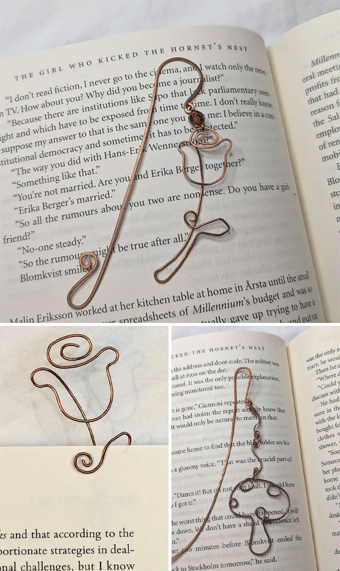 A handmade project bookmark made from copper wire, shaped like a flower, nestled in the pages of a book.