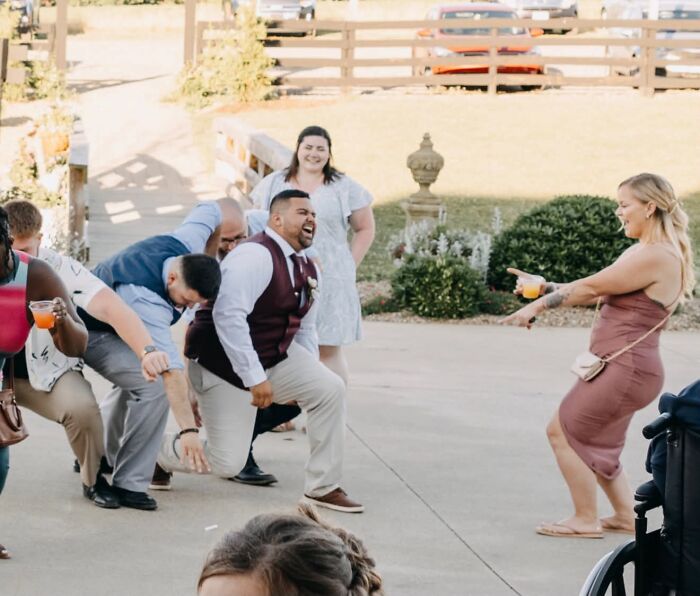 Wedding guests laughing and dancing outdoors, making for a funny wedding photo.