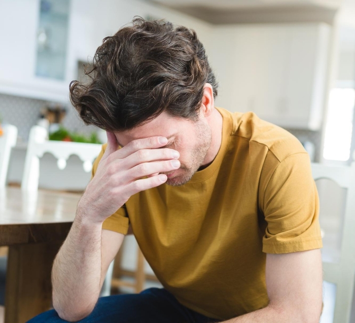 A man with a pained expression, questioning his marriage due to his wife's shocking beliefs and difficulty conceiving children.