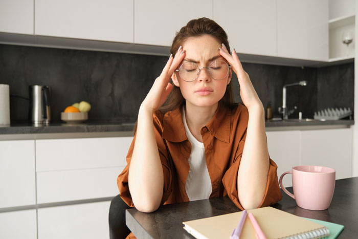 Stressed woman holding her head, likely dealing with conflict from MIL who wants her to leave her son. Stressed woman holding her head, likely dealing with conflict from MIL who wants her to leave her son.