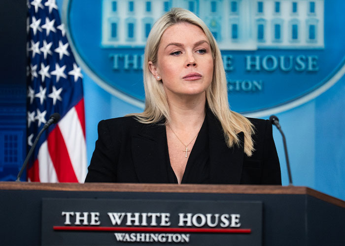Karoline Leavitt as press secretary at a White House podium, looking serious.