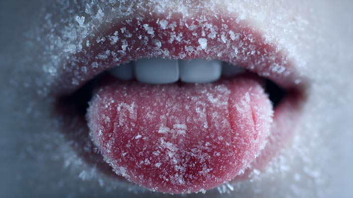Close-up of a person's mouth and tongue covered in snow, metaphor for dumb work rules and cold office.
