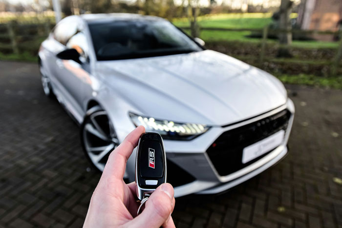 A hand holding a car key with an Audi RS logo, subtly alluding to topics beyond wife material.