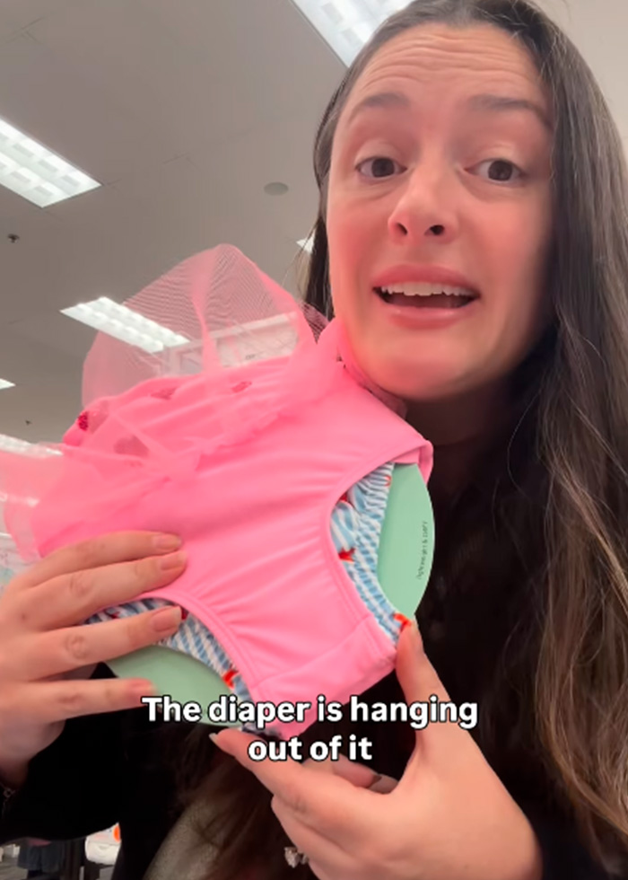 A girl mom shows a pink children's swimsuit where a diaper hangs out, addressing a concerning trend in kids clothing. A girl mom shows a pink children's swimsuit where a diaper hangs out, addressing a concerning trend in kids clothing.