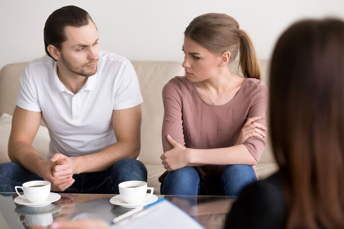 Couple in a therapy session, looking displeased, discussing why they walked out without their therapist.