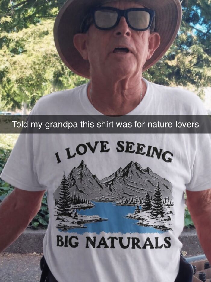 An older man wearing a white iconic shirt with mountains, trees, a lake, and the text: I LOVE SEEING BIG NATURALS.
