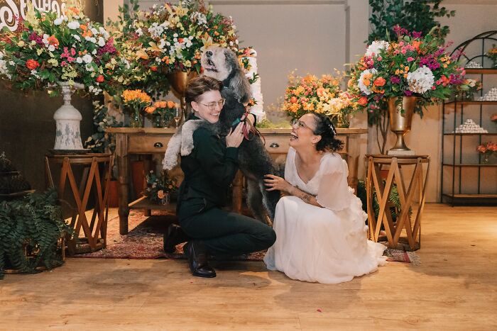 A couple laughing with their dog, creating an iconic and funny wedding photo.
