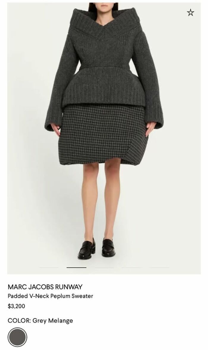 A woman in a grey padded V-neck peplum sweater and a grid-patterned skirt that looks like a hilariously bad fashion statement.