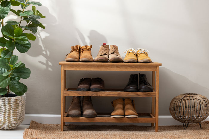 A shoe rack filled with various shoes, reflecting unhinged house rules about footwear in the family home.