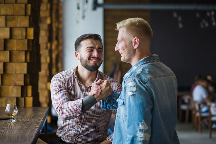 Two men, a hubby and his best friend, shaking hands with big smiles, showcasing their friendship. Two men, a hubby and his best friend, shaking hands with big smiles, showcasing their friendship.