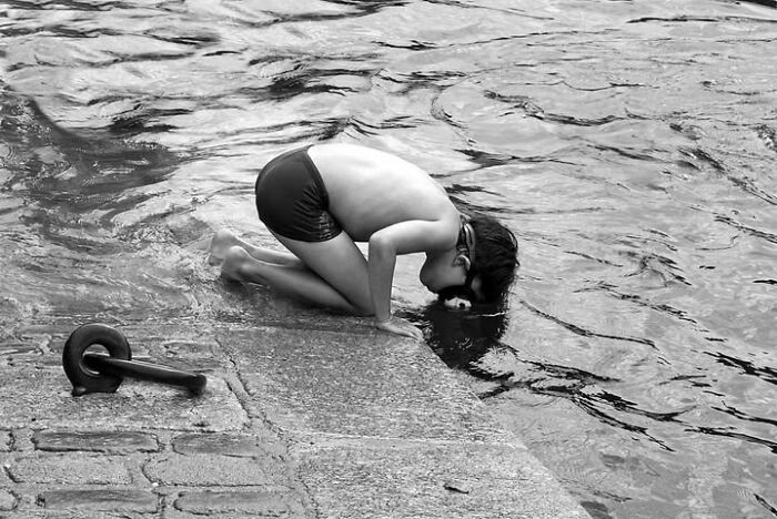 Black and white perfectly timed street photos capture a child playing by the water in Paris, France.